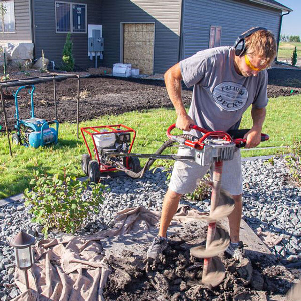 Man Using Little Beaver Mechanical Earth Drill